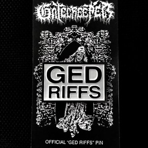 May include: Black and white image of a pin with the words "GED RIFFS" in white letters on a black background. The pin is surrounded by a black and white image of a castle.