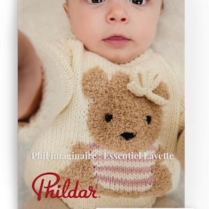Op de afbeelding: Een baby draagt een crèmekleurige gebreide trui met een bruin teddybeerontwerp. De beer heeft een roze en wit gestreept shirt aan. De trui is van de collectie "Phil imaginaire + Essentiel Layette", met het "Phildar" logo.