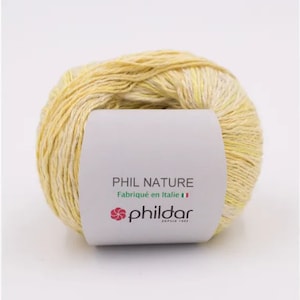 May include: A ball of yellow and white yarn with a label that reads "PHIL NATURE Fabriqu&eacute; en Italie" and a pink flower logo with the text "phildar DEPUIS 1903".
