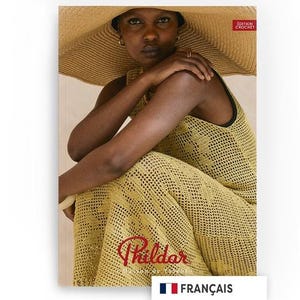 Può includere: Una donna indossa un abito all'uncinetto giallo e un cappello di paglia a tesa larga. L'immagine presenta il testo "Phildar" in corsivo. Sono visibili anche la bandiera francese e la parola "Français".