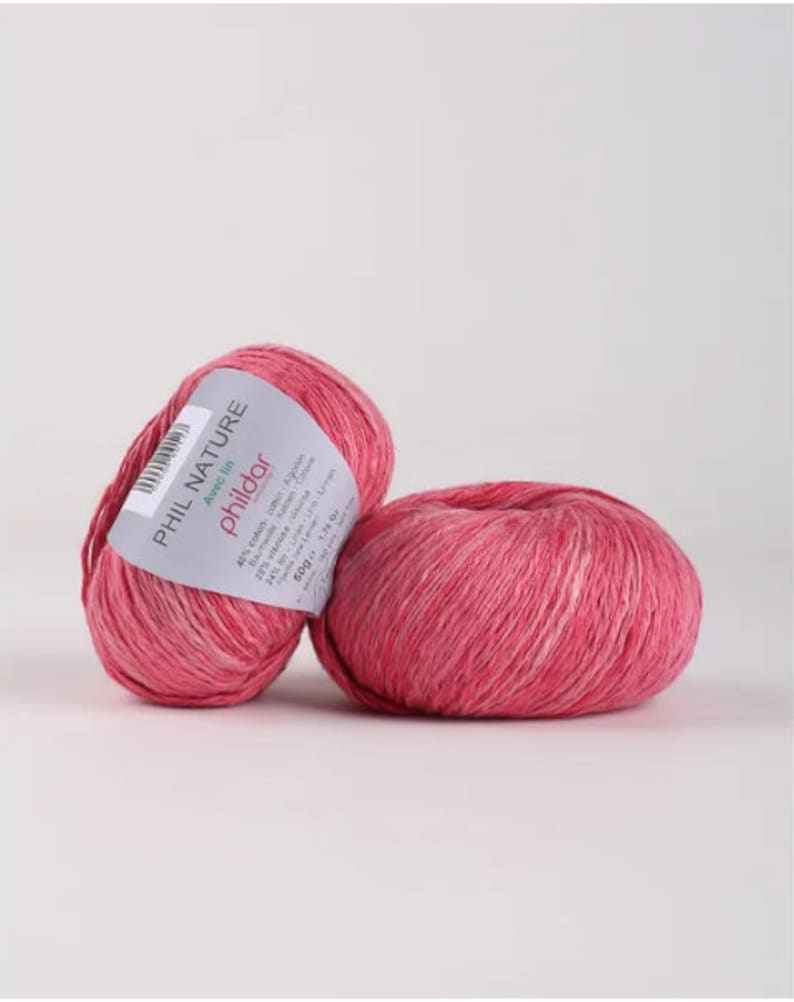May include: Two balls of pink Phil Nature yarn with the label "Avec l'in Philodor" and details about the yarn composition and care instructions.