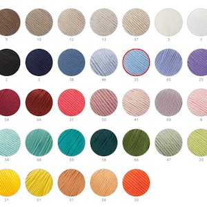 Può includere: Una tabella colori di gomitoli di filato in varie tonalità. L'immagine evidenzia un filato azzurro, contrassegnato con il numero 35. Altri colori includono marrone, nero, blu, rosa, verde, giallo e arancione. Il filato è probabilmente per progetti di maglieria o uncinetto.