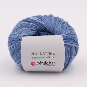 May include: A ball of blue yarn with a white label that reads "PHIL NATURE Fabriqu&eacute; en Italie" and a red logo that says "phildar DEPUIS 1903".