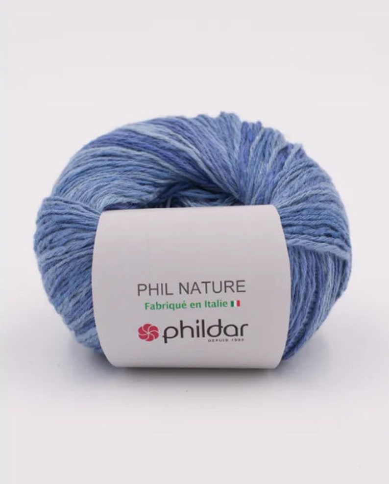 May include: A ball of blue yarn with a white label that reads "PHIL NATURE Fabriqu&eacute; en Italie" and a red logo that says "phildar DEPUIS 1903".