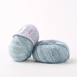 May include: Two balls of light blue yarn with white flecks. The yarn is labeled "Phil Nature" and "Phildar" with a pink logo.