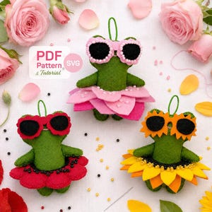 May include: Three green felt frog ornaments with hanging loops. One wears pink sunglasses and a pink petal skirt, one wears red sunglasses and a red petal skirt, and one wears yellow sunglasses and a yellow sunflower petal skirt. Text reads PDF Pattern & Tutorial.