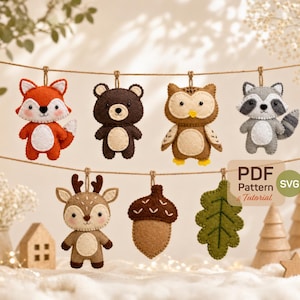 May include: A selection of felt woodland animal decorations, including a fox, bear, owl, raccoon, deer, acorn, and leaf, suspended from a string. The ornaments are in various colours, with the text "PDF Pattern & Tutorial SVG" in the lower right corner.