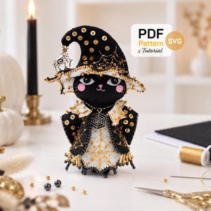 Pode incluir: Uma boneca de gato de feltro preto com chapéu de bruxa e capa a condizer, decorados com lantejoulas douradas e bordados de teia de aranha. A boneca tem bochechas cor-de-rosa, olhos pretos e um pendente de aranha. Texto PDF Pattern & Tutorial.