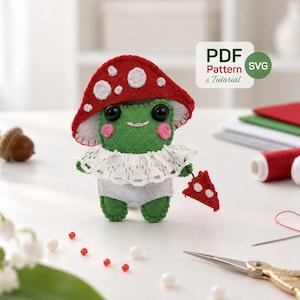 Pode incluir: Um peluche de sapo em feltro verde com um chapéu de cogumelo vermelho com pintas brancas, um colarinho de renda branca e uma fralda cinzenta. O sapo segura uma pequena peça triangular vermelha com pintas brancas. Uma etiqueta diz PDF Pattern & Tutorial e SVG.