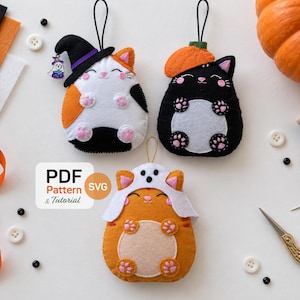 May include: Three felt cat ornaments featuring Halloween themes: a calico cat with a witch hat, a black cat with a pumpkin hat, and an orange cat with a ghost hood. A white label displays the text PDF Pattern & Tutorial SVG.