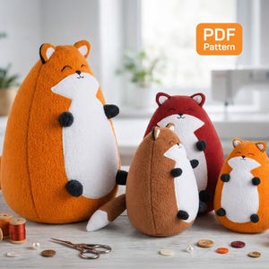 May include: Four plush fox toys in varying sizes and colors: orange, brown, and red. Each fox has a white belly and face, black paws, and a smiling expression. The image includes sewing supplies and a "PDF Pattern" label.