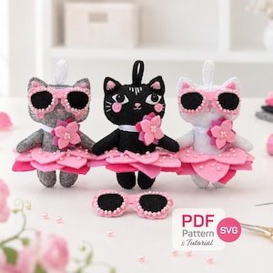 May include: Three felt cat dolls in gray, black, and white, each wearing a pink petal skirt, a white collar with a pink flower, and pink-rimmed sunglasses. A separate pair of pink-rimmed sunglasses sits in front. Text reads PDF Pattern & Tutorial.