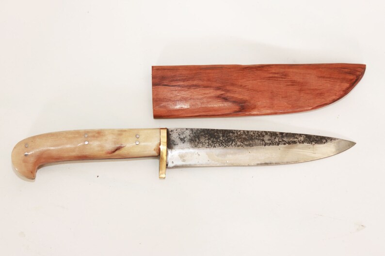 May include: A knife with a bone handle and a metal blade. The knife is in a wooden sheath.