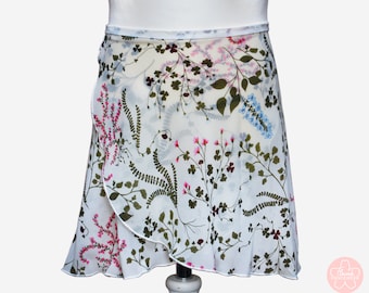Può includere: Gonna da ballo bianca con stampa floreale con foglie verdi, fiori rosa e blu. La gonna ha un orlo arricciato.