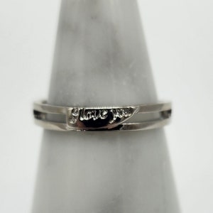 May include: A silver ring with the words "I love you" engraved on the band.