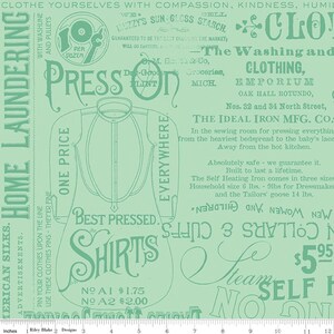 May include: A light green fabric with vintage laundry-themed text and illustrations. The design includes the words "Press On," "Shirts," and "Home Laundering." The fabric also features a drawing of a shirt and various advertisements.