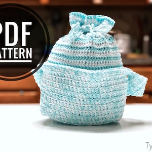 Pode incluir: Um pegador de panela de crochê listrado azul turquesa e branco com um cordão de ajuste na parte superior. O pegador de panela está sobre uma superfície branca. O texto "PDF PATTERN" é visível no fundo.