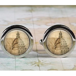 May include: A pair of silver cufflinks with a vintage architectural drawing of a dome on each cufflink.