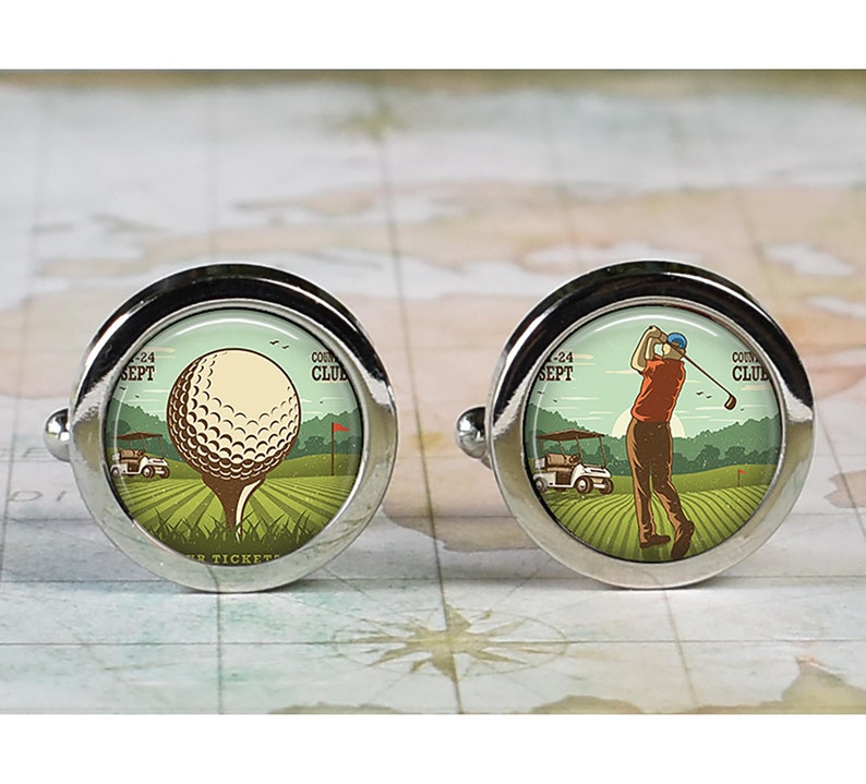 May include: A pair of silver cufflinks with a golf theme. One cufflink features a golf ball on a tee with a golf cart in the background. The other cufflink features a golfer swinging a golf club with a golf cart in the background. Both cufflinks have the text "Country Club" and "Sept 24" on them.