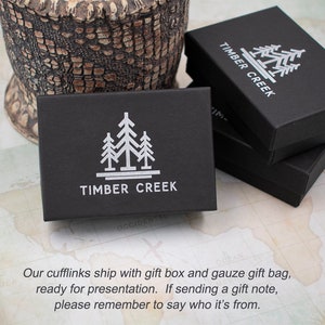 May include: Black gift box with a white logo of three stylized trees and the text "TIMBER CREEK".