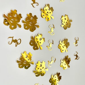 May include: Gold confetti with the Chinese character for double happiness, a traditional symbol for weddings.