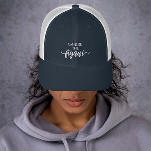 Può includere: Un cappello da camionista blu navy e bianco con il testo "Where the figawi" ricamato in bianco sul davanti.