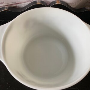 May include: White ceramic mixing bowl with rounded sides and two handles. The bowl is empty and appears to be new.