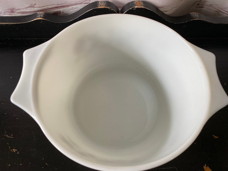 May include: White ceramic mixing bowl with rounded sides and two handles. The bowl is empty and appears to be new.