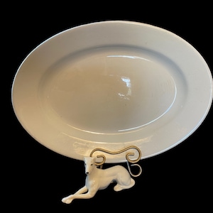 May include: White oval serving platter with a smooth, glossy finish. The platter is made of ceramic and is ideal for serving food.