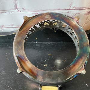 K&ouml;nnte beinhalten: Servierst&auml;nder aus versilbertem Metall mit einem verzierten, durchbrochenen Design. Der St&auml;nder hat vier F&uuml;&szlig;e und eine runde Oberseite.