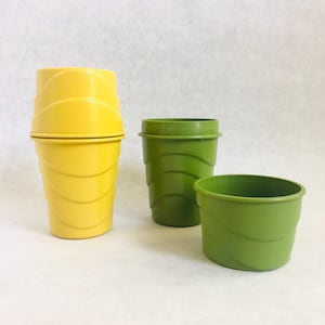 Puede incluir: Tres macetas de pl&aacute;stico en tonos amarillos y verdes. La m&aacute;s grande es amarilla y apilada, la del medio es verde y la m&aacute;s peque&ntilde;a es verde claro. Todas tienen un dise&ntilde;o acanalado.
