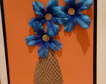 Flores azules en florero de oro