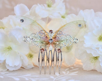 May include: A delicate butterfly hair comb with a silver finish and iridescent wings. The comb features a detailed filigree design and sparkling rhinestones.