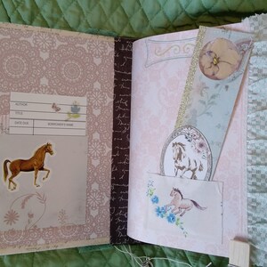 Puede incluir: Diario abierto con una pegatina de caballo y un marcap&aacute;ginas. El diario tiene un patr&oacute;n floral rosa y un ribete de encaje. El marcap&aacute;ginas presenta una ilustraci&oacute;n de caballo y una flor. El diario tiene una etiqueta con campos para autor, t&iacute;tulo, fecha de vencimiento y nombre del prestatario.