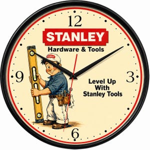 May include: A round wall clock with a black frame and a cream-colored face. The clock features the Stanley Hardware & Tools logo, a cartoon character holding a yellow level, and the text Level Up With Stanley Tools in black lettering.