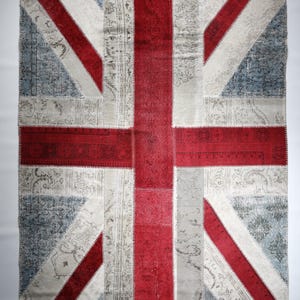 May include: A patchwork rug with the design of the Union Jack flag. The rug is made of different colored fabrics, including red, white, and blue. The rug is a great way to add a touch of British style to your home.