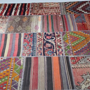 Könnte beinhalten: Ein bunter Patchwork-Teppich mit verschiedenen Mustern und Farben, darunter Rot, Blau, Grün und Gelb. Der Teppich besteht aus verschiedenen Stoffstücken, die zusammengenäht wurden.