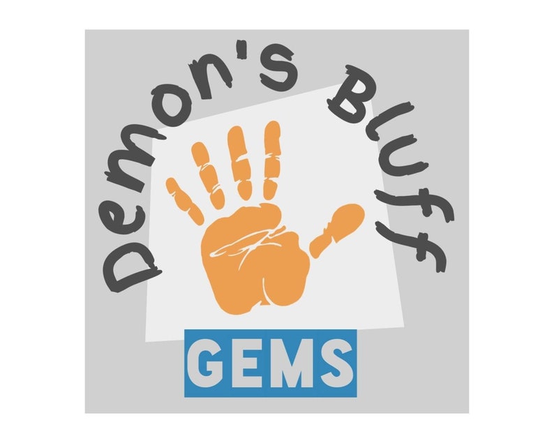 Pode incluir: Um fundo branco com uma impress&atilde;o de m&atilde;o laranja. A impress&atilde;o de m&atilde;o &eacute; cercada pelo texto "Demon's Bluff" em preto. Abaixo da impress&atilde;o de m&atilde;o h&aacute; um ret&acirc;ngulo azul com o texto "GEMS" em branco.