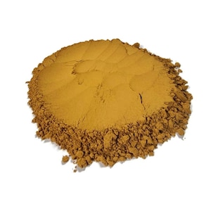 Pode incluir: Um monte de pó de canela moído marrom e solto sobre um fundo branco.