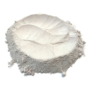 Pode incluir: Um monte de p&oacute; branco, possivelmente argila ou farinha, sobre um fundo branco.
