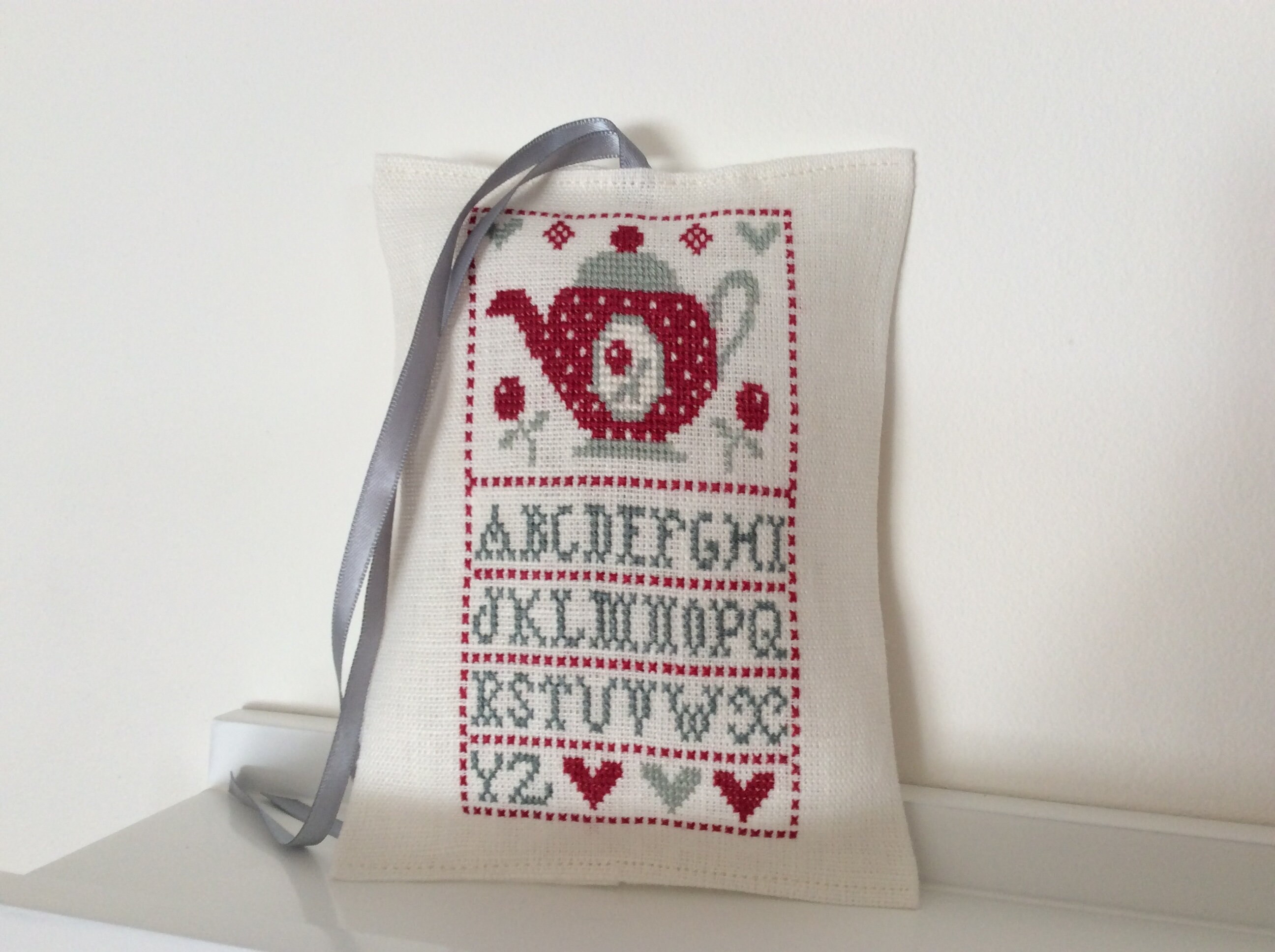 Coussinet Le Thé Broderie Au Point Compté sur Lin Blanc Cassé .