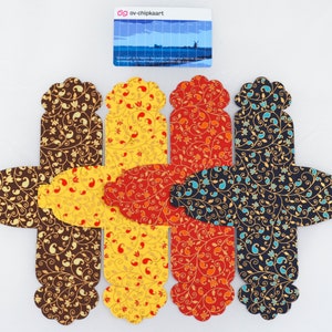May include: Four favor boxes with a paisley pattern in brown, yellow, orange, and blue. The boxes are made of paper and have a scalloped edge.