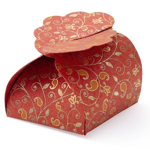 May include: A red and gold patterned favor box with a scalloped top. The box is made of paper and has a floral design.