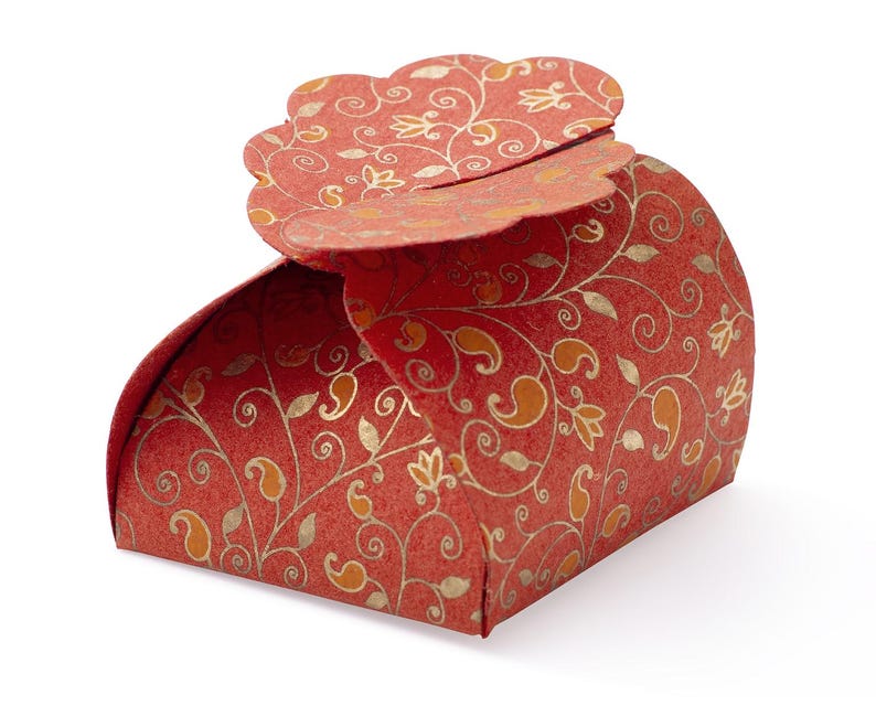 May include: A red and gold patterned favor box with a scalloped top. The box is made of paper and has a floral design.