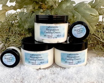 May include: Four round containers of Magnesium Cooling Cream with black lids and white labels featuring blue watercolor accents. The labels display the text myflowerchildco, Magnesium Cooling Cream, All Natural, and 4fl oz, external use only.
