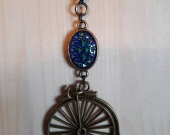 sautoir bronze steampunk avec bicyclette et cabochon bleu cristal