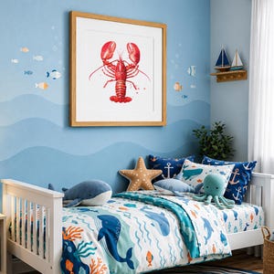 May include: A square framed wall art print featuring a vibrant red lobster illustration centered on a white background. The artwork is displayed on a light blue wall decorated with small fish decals and a wooden shelf holding two small model sailboats.