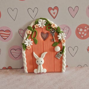Door for the tooth fairy (coral-colored door with a white rabbit)