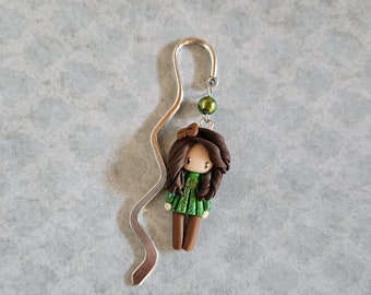 Bookmark little girl with brown hair, green top and brown bottom.