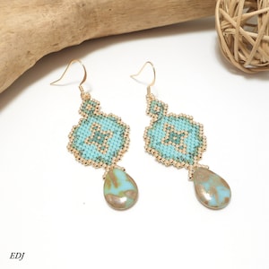 May include: A pair of gold dangle earrings with turquoise and gold beadwork and a teardrop-shaped turquoise stone pendant.